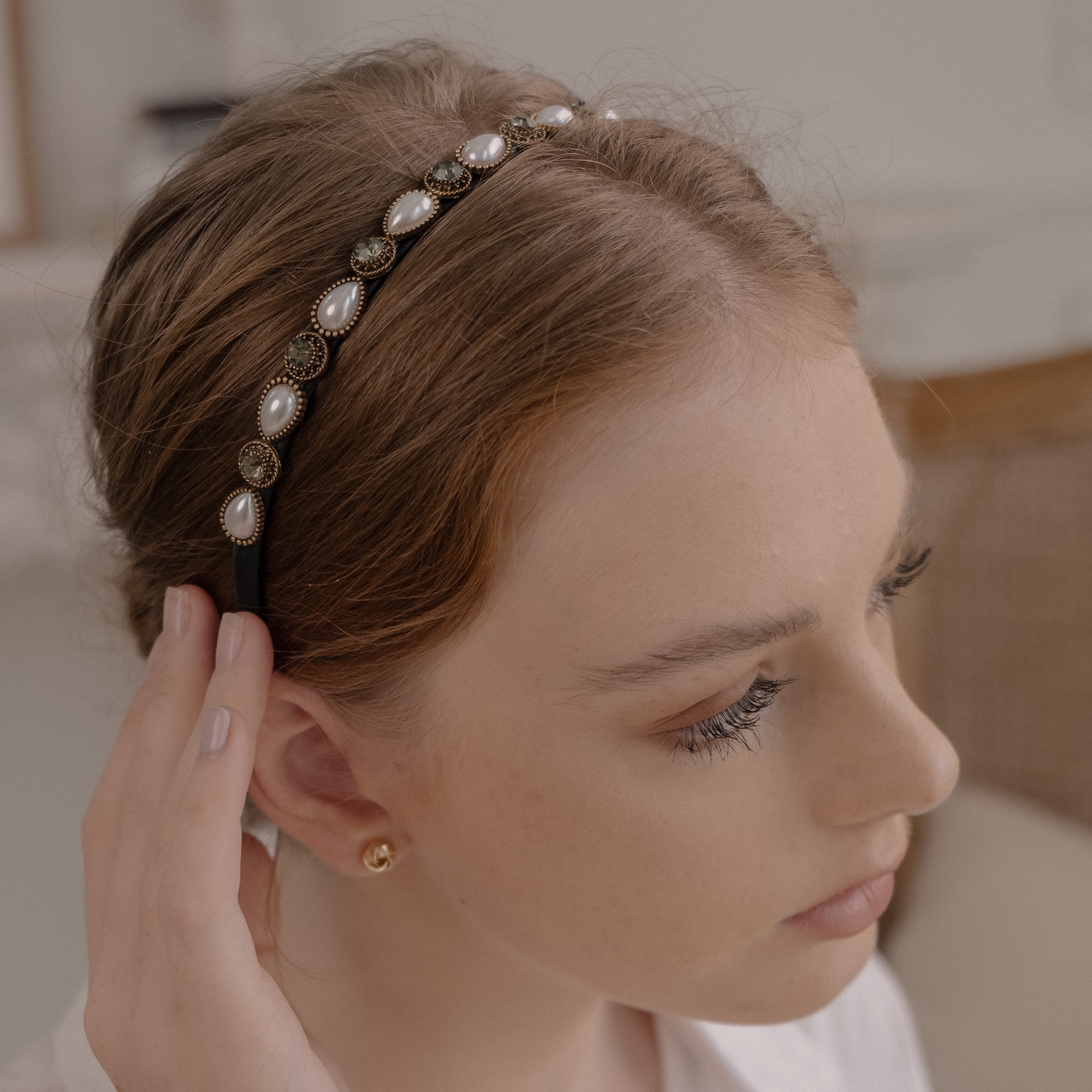 White and cream pearls and stones adorn a delicate gold headband, perfect for weddings and special occasions.