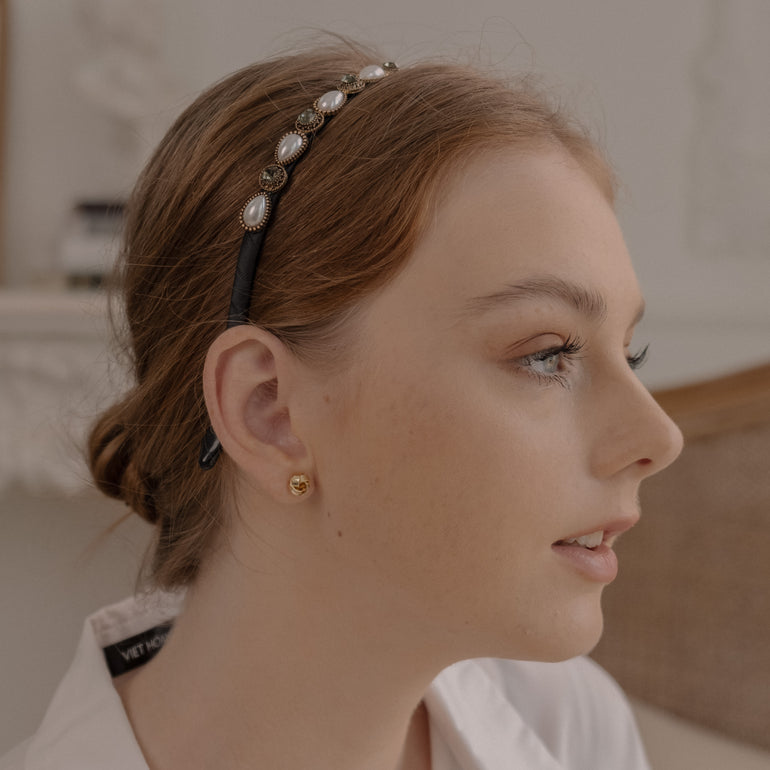 White and cream pearls and stones adorn a delicate gold headband, perfect for weddings and special occasions.