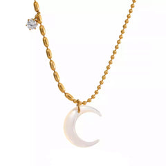 A stylish woman wearing a beautiful 18K gold plated moon pendant necklace. The natural shell pendant shines against her skin, adding a touch of celestial charm to her outfit. The delicate yet sturdy chain ensures the pendant sits beautifully on her neckline. The necklace is waterproof, making it perfect for daily wear