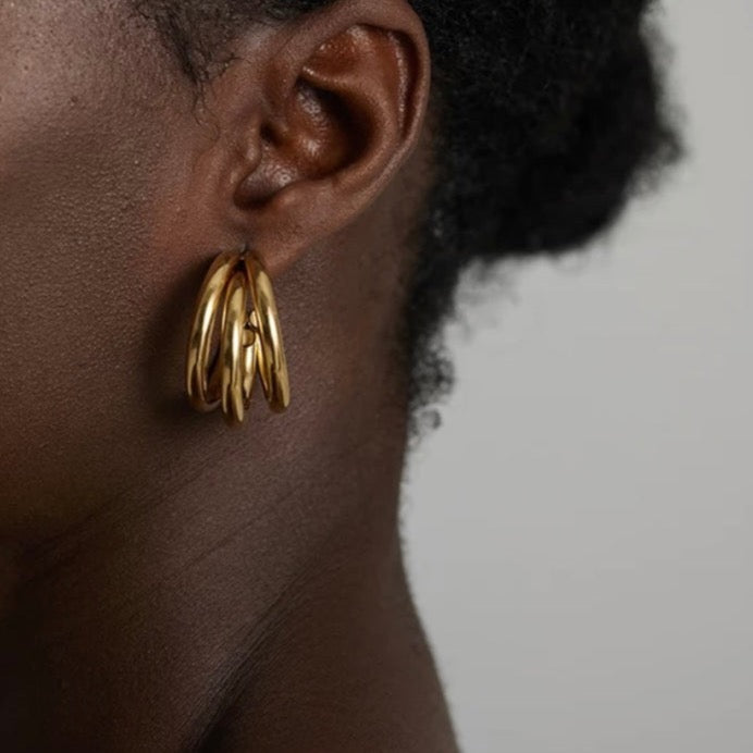 A stylish woman wearing 18k gold plated triple stack hoop earrings in Australia, adding a touch of elegance to her outfit