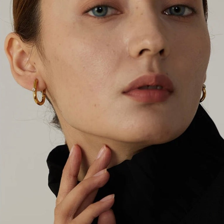 Photo of a woman wearing rectangle gold hoop earrings in Sydney, Australia