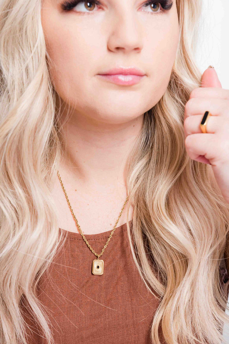 She is wearing gold sun pendant necklace in gold filled. The necklace has a black gemstone pendant and rope chain. The necklace is sold in Australia and ship worldwide. This cute necklace is waterproof and does not turn your skin green 